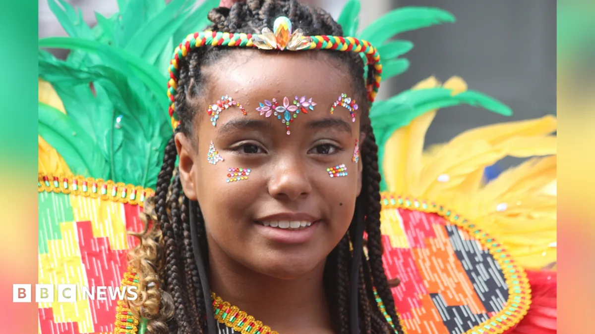Crowds, flags and brightly costumed revellers at Notting Hill Carnival in west London