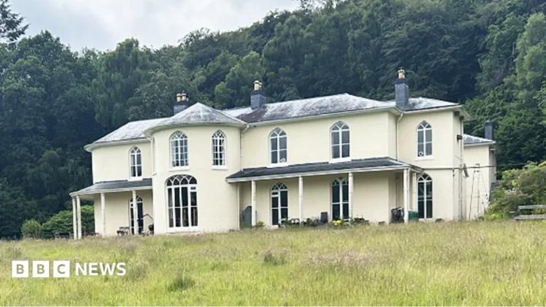 Residents walking beside a Georgian hall and its grounds in rural Powys