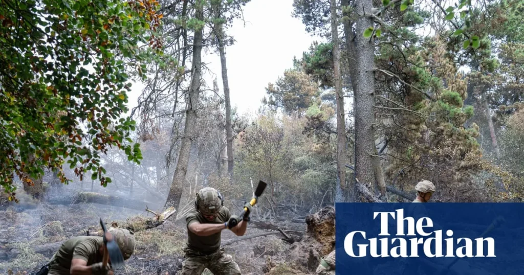 Firefighters and soldiers working on a smoke-blackened hillside near Blaenavon