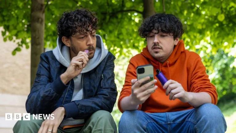 A person holding an e-cigarette while smoke-free quitting support is promoted