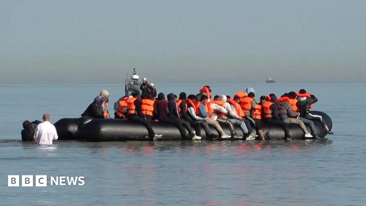 Migrants board a small boat from a beach in northern France during a daytime Channel crossing
